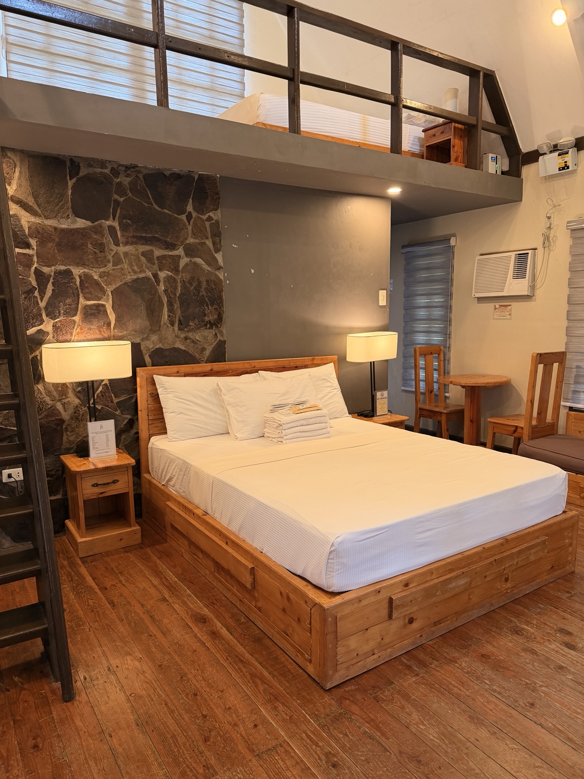 Wood-lined villa room with a bed and loft